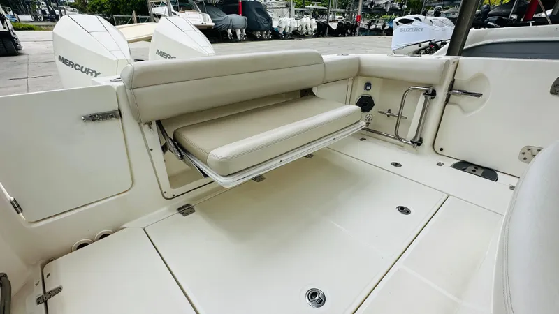 Slide: The Image of 2020 Boston Whaler 330 Outrage boat interior with foldable seating and Mercury engines. - 14