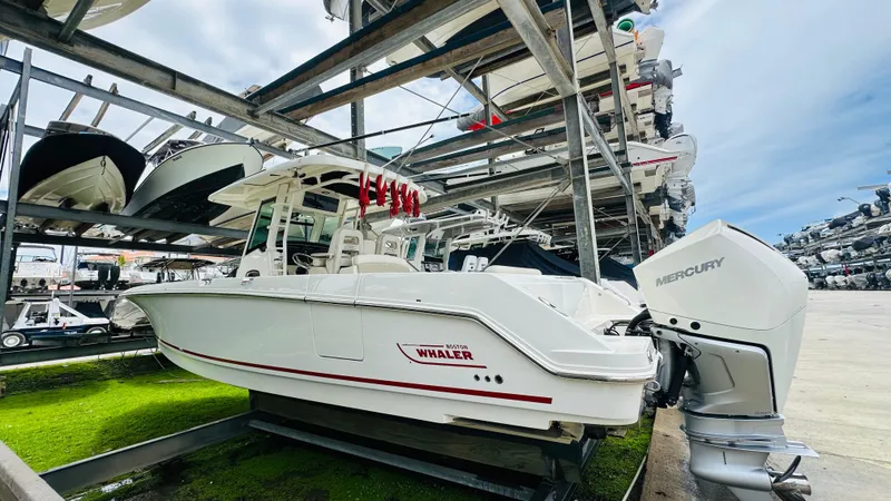 Slide: The Image of 2020 Boston Whaler 330 Outrage boat in storage, featuring Mercury outboard engines. - 18
