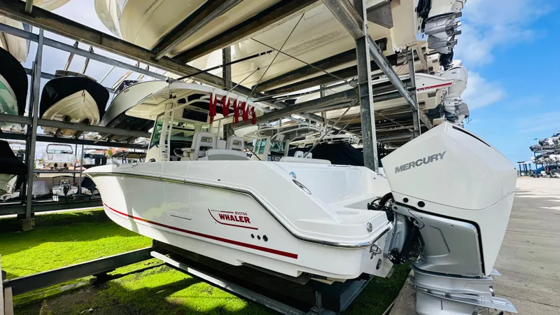 Slide: The Image of 2020 Boston Whaler 330 Outrage boat with Mercury engine in storage facility. - 19
