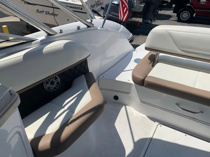 Slide: The Image of 2014 Cobalt 302 boat interior with white and brown seating, docked near other boats. - 12