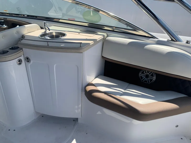 Slide: The Image of Interior of a 2014 Cobalt 302 boat featuring a sink and cushioned seating area. - 13