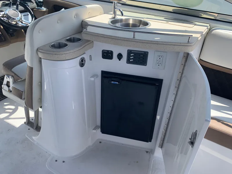 Slide: The Image of 2014 Cobalt 302 boat interior with sink, mini fridge, and control panel. - 14