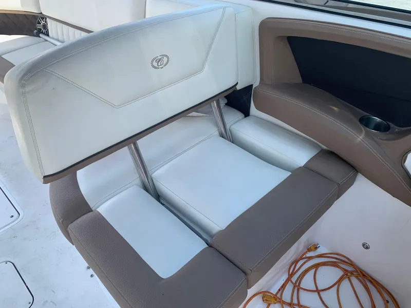 Slide: The Image of 2014 Cobalt 302 boat interior with beige and white seating, cup holder, and orange rope. - 16