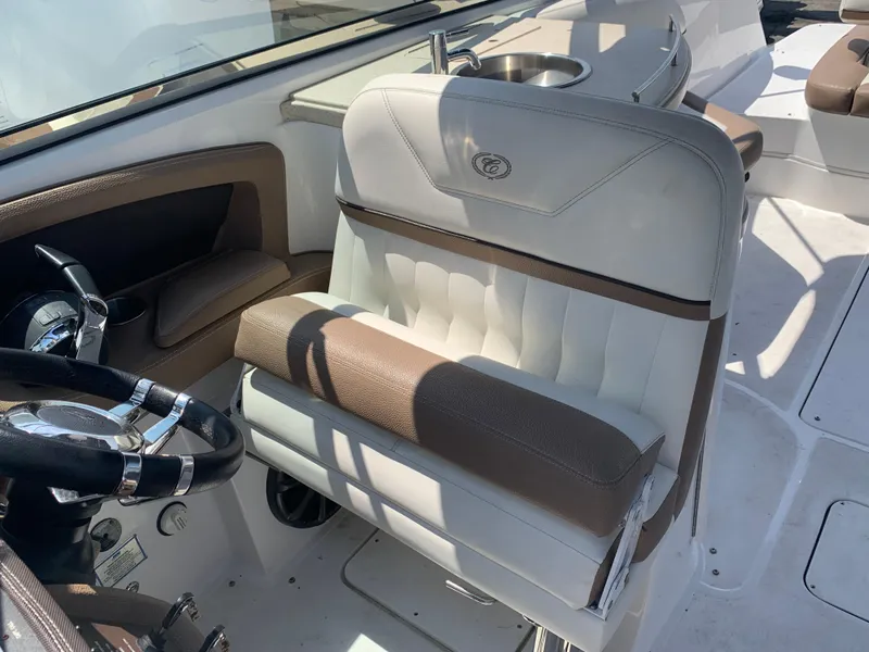 Slide: The Image of 2014 Cobalt 302 boat interior with steering wheel and cushioned seating. - 18