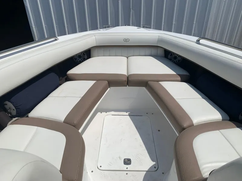 Slide: The Image of 2014 Cobalt 302 boat interior with white and brown cushioned seating. - 26