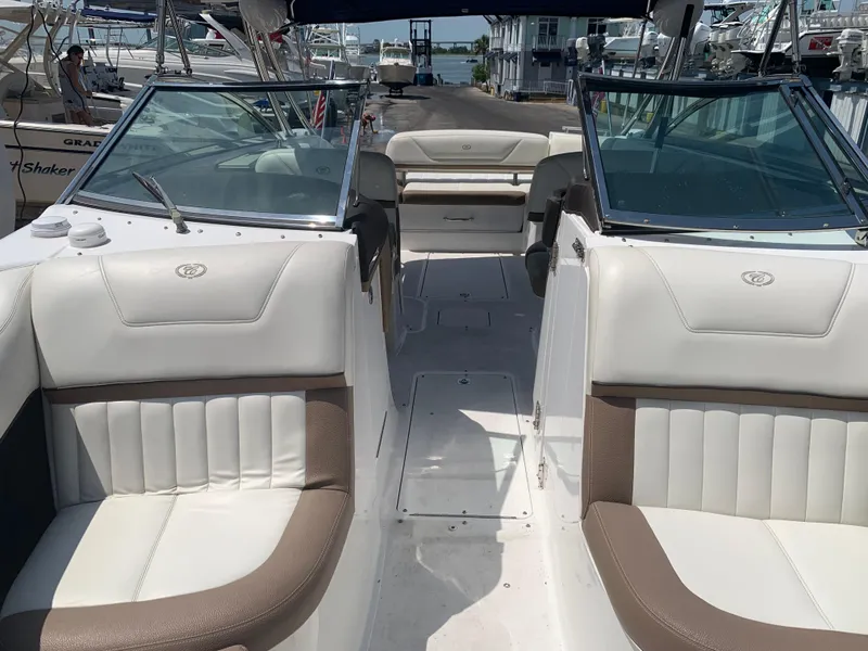 Slide: The Image of 2014 Cobalt 302 boat interior with white and beige seating, docked at marina. - 27