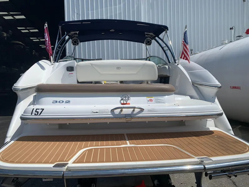 Slide: The Image of 2014 Cobalt 302 boat with teak swim platform, docked near a warehouse. - 3