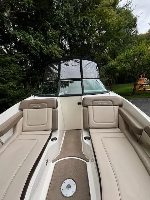 Slide: The Image of 2012 Sea Ray 260 Sundeck boat with beige seating, surrounded by lush greenery. - 10
