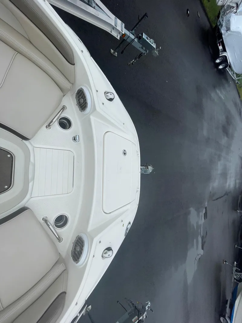 Slide: The Image of 2012 Sea Ray 260 Sundeck boat on trailer, top view, beige seating, parked on wet pavement. - 12