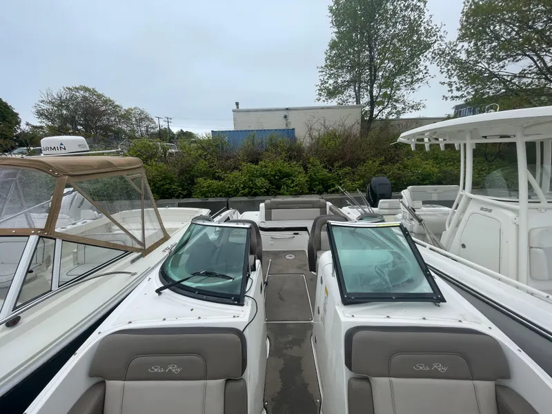 Slide: The Image of 2012 Sea Ray 260 Sundeck boat with dual windshields, docked outdoors. - 13