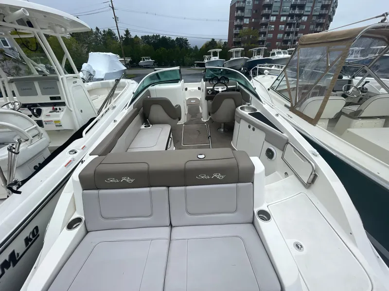 Slide: The Image of 2012 Sea Ray 260 Sundeck boat with spacious seating and modern design in a marina. - 16
