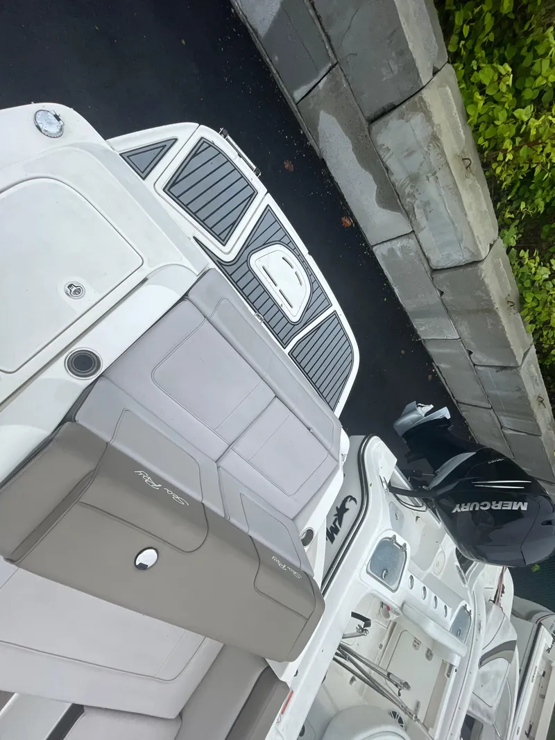 Slide: The Image of 2012 Sea Ray 260 Sundeck boat with Mercury engine, docked near a stone wall. - 17