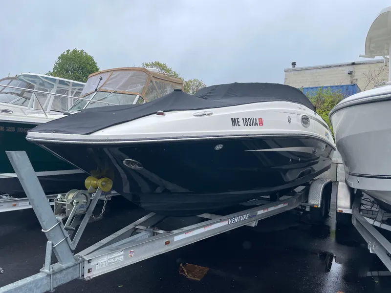 Slide: The Image of 2012 Sea Ray 260 Sundeck boat on trailer, covered and parked outdoors. - 3
