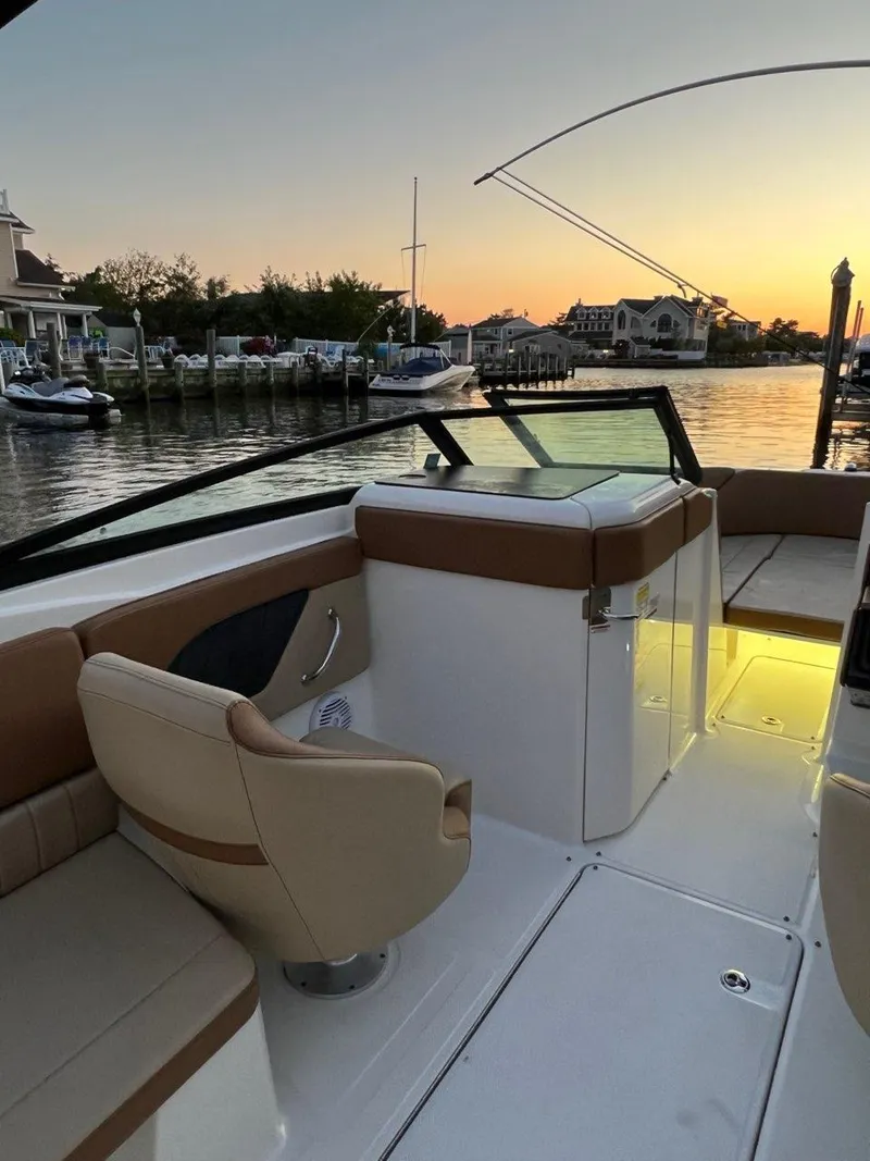 Slide: The Image of 2018 Sea Ray SPX 230 Outboard boat interior at sunset, docked in a serene marina. - 13