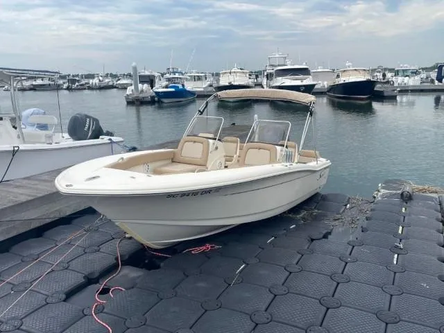 Slide: The Image of 2022 Scout Sport 195 Dorado boat docked at a marina with other vessels. - 1