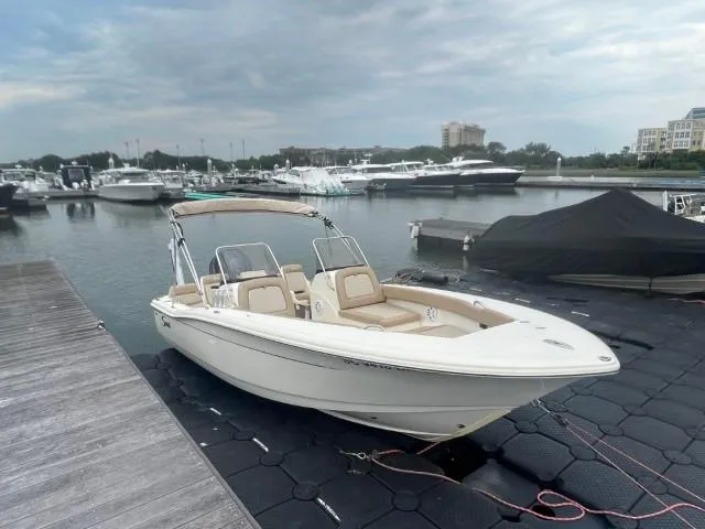 Slide: The Image of 2022 Scout Sport 195 Dorado boat docked at marina under cloudy sky. - 2