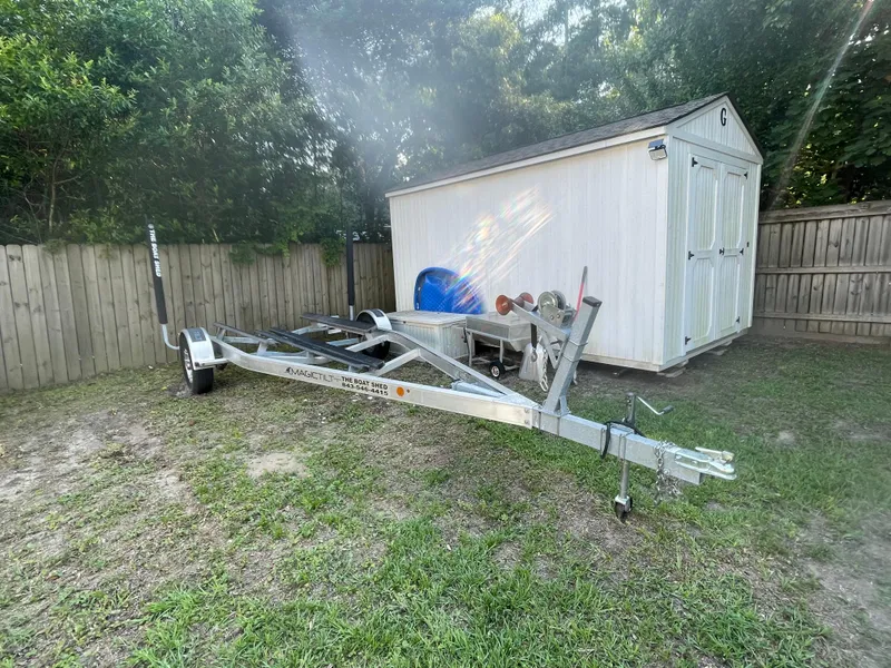 Slide: The Image of Trailer for 2022 Scout Sport 195 Dorado beside a white shed in a fenced yard. - 20