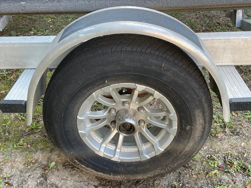 Slide: The Image of Trailer wheel of a 2022 Scout Sport 195 Dorado boat on grass. - 22