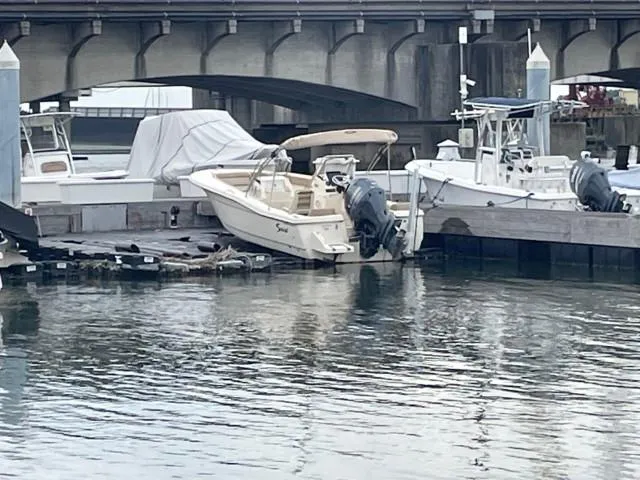 Slide: The Image of 2022 Scout Sport 195 Dorado boat docked near a bridge. - 4