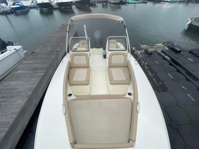 Slide: The Image of 2022 Scout Sport 195 Dorado boat docked, featuring beige seating and sleek design. - 7