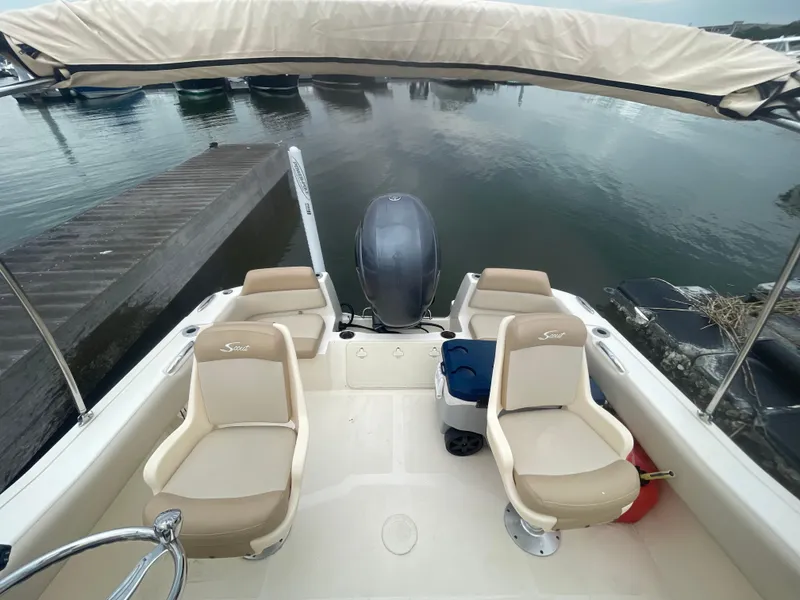 Slide: The Image of 2022 Scout Sport 195 Dorado boat interior with seating, docked at marina. - 8