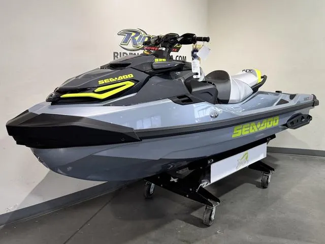 Slide: The Image of 2025 Sea-Doo Waverunner RXT-X in showroom, sleek design, gray and yellow accents. - 1