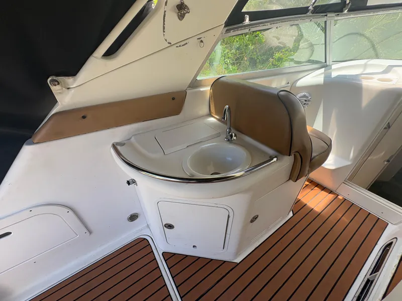 Slide: The Image of 1996 Sea Ray Sundancer 350 interior with sink and seating on teak flooring. - 10