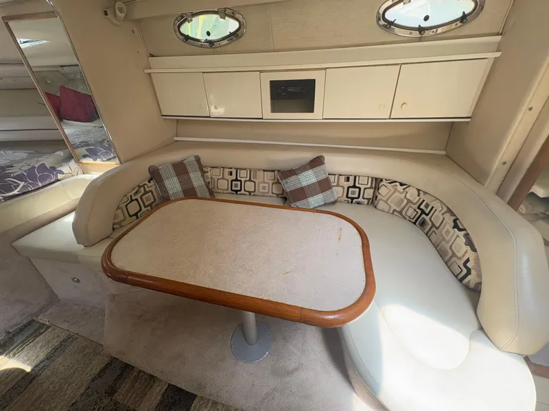Slide: The Image of 1996 Sea Ray Sundancer 350 interior with cozy seating and dining area. - 18