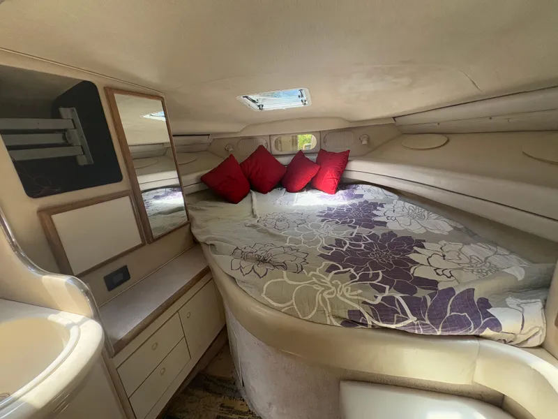 Slide: The Image of 1996 Sea Ray Sundancer 350 cabin interior with floral bedding and red cushions. - 19