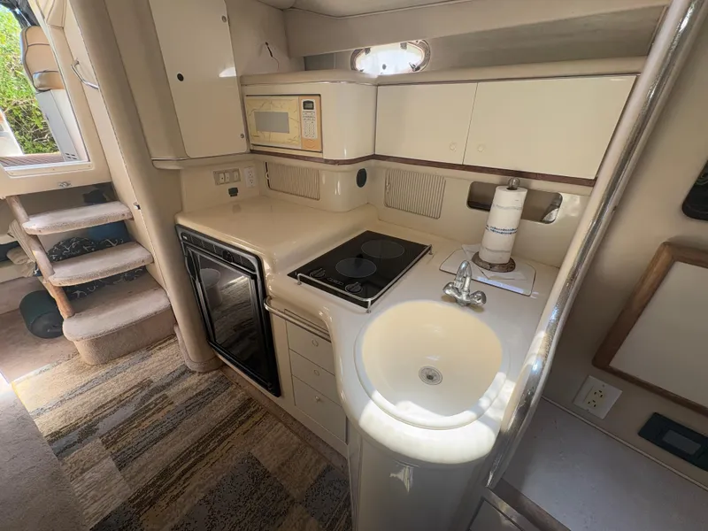 Slide: The Image of 1996 Sea Ray Sundancer 350 interior kitchen with stove, sink, and microwave. - 20