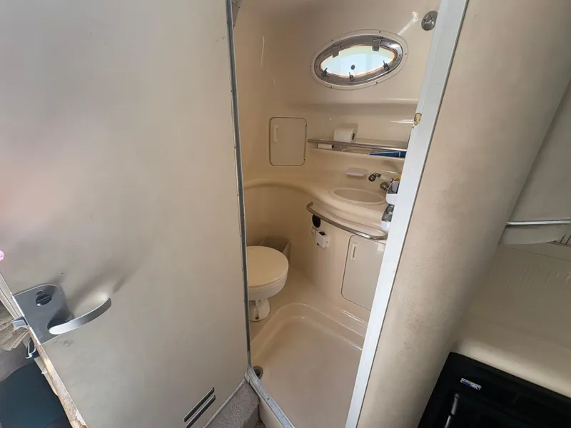 Slide: The Image of 1996 Sea Ray Sundancer 350 bathroom with compact design and porthole window. - 21