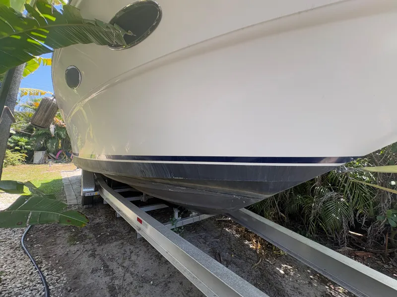 Slide: The Image of 1996 Sea Ray Sundancer 350 on trailer, side view, surrounded by greenery. - 4