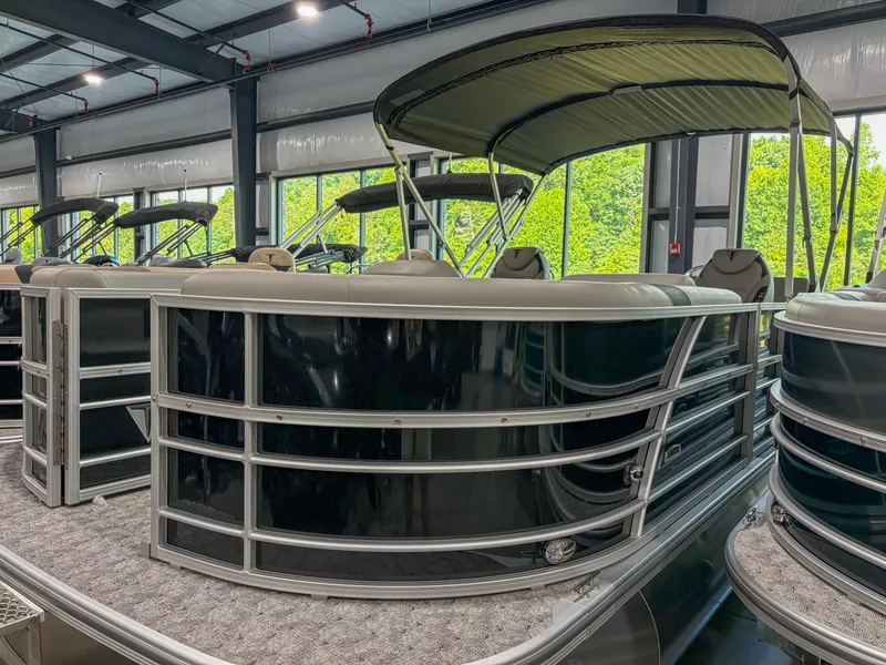 The Image of 2025 Trifecta 24 UL LE pontoon boat in showroom, featuring sleek design and canopy. - 1