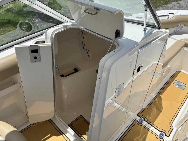 Slide: The Image of 2019 Key West 239 DFS boat interior with open storage compartment and beige seating. - 11