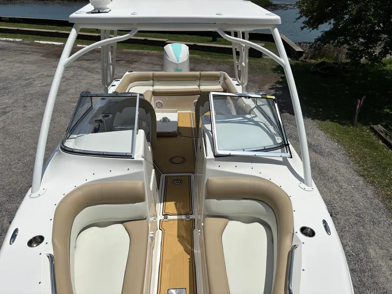 Slide: The Image of 2019 Key West 239 DFS boat with open seating and sleek design, parked on gravel. - 2
