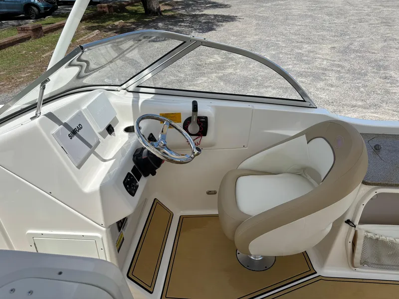 Slide: The Image of 2019 Key West 239 DFS boat cockpit with steering wheel and beige captain's chair. - 4