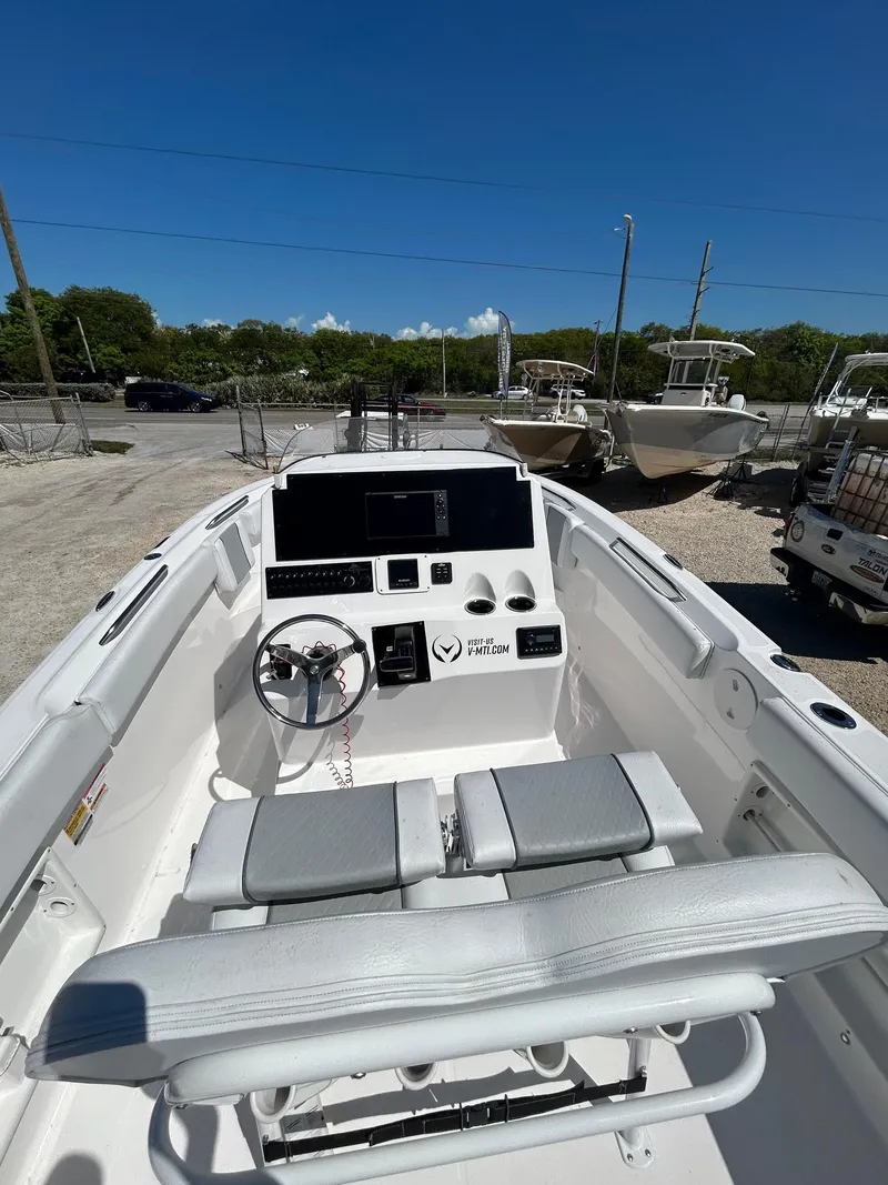 Slide: The Image of 2022 Aquasport 2100 boat interior with steering wheel and seating, under clear blue sky. - 3