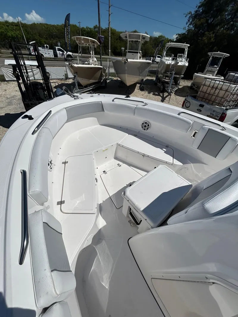Slide: The Image of 2022 Aquasport 2100 boat interior with seating and storage, displayed outdoors. - 6