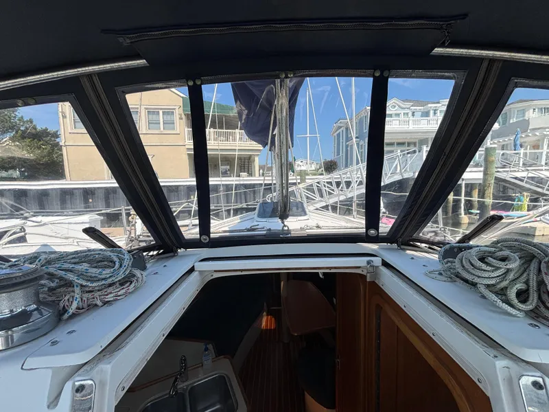 Slide: The Image of Interior view of a 1998 Catalina 320 sailboat cockpit with ropes and marina background. - 13