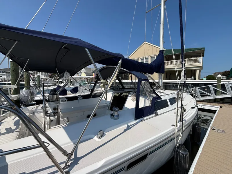 Slide: The Image of 1998 Catalina 320 sailboat docked at marina with blue canopy and clear sky. - 2