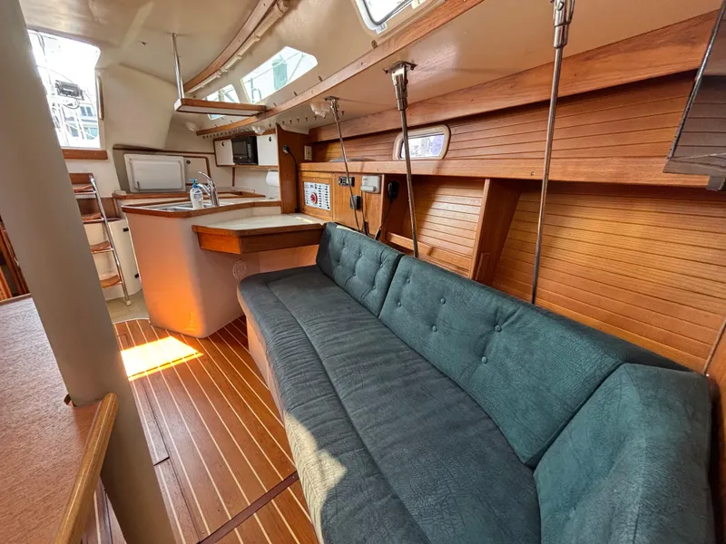 Slide: The Image of Interior of 1998 Catalina 320 sailboat with wooden paneling and blue cushioned seating. - 25