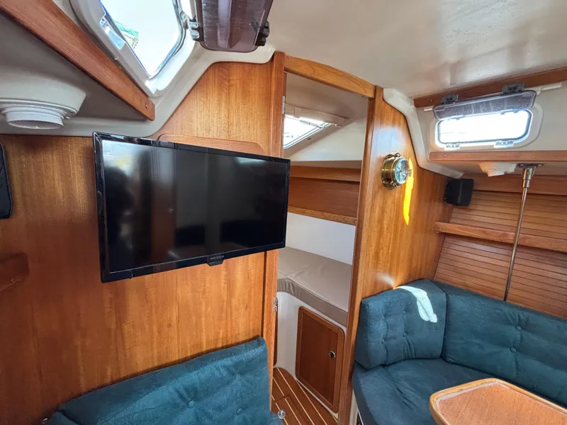 Slide: The Image of Interior of 1998 Catalina 320 sailboat with TV, seating, and wood paneling. - 26