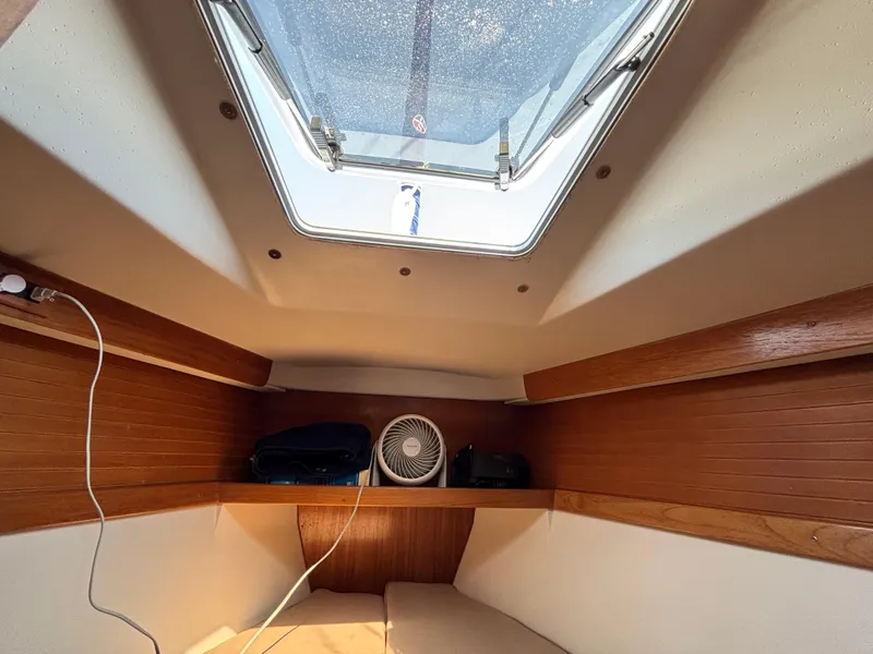 Slide: The Image of Interior cabin of a 1998 Catalina 320 sailboat with a skylight and wooden accents. - 28