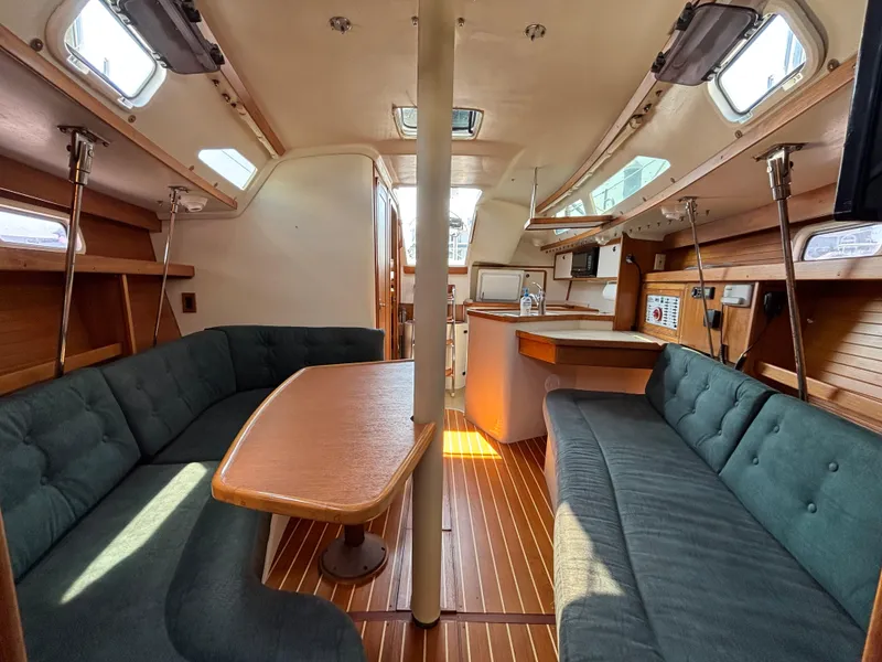 Slide: The Image of Interior of a 1998 Catalina 320 sailboat with cozy seating and wooden finishes. - 29