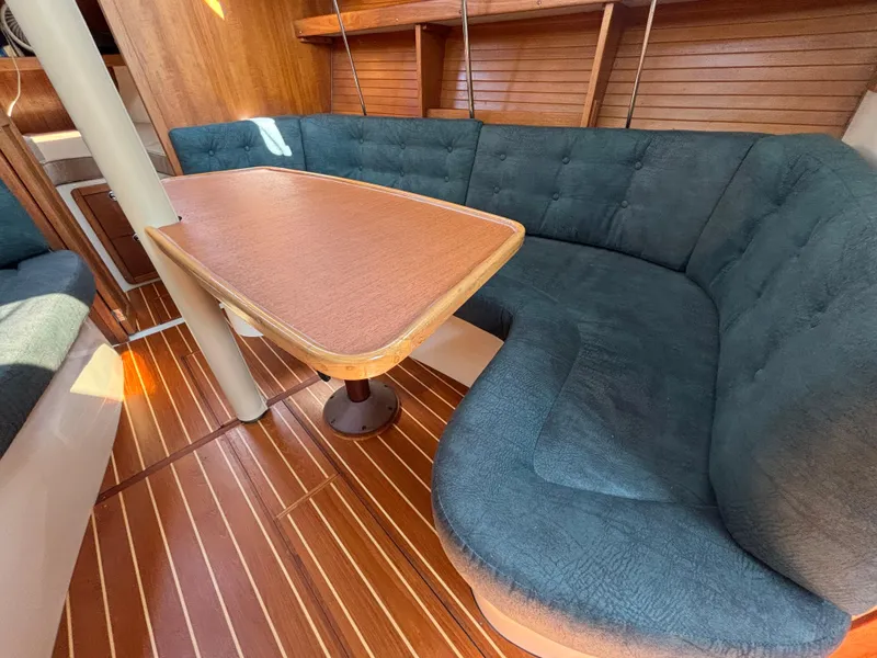 Slide: The Image of 1998 Catalina 320 yacht interior with wooden table and cushioned seating. - 35
