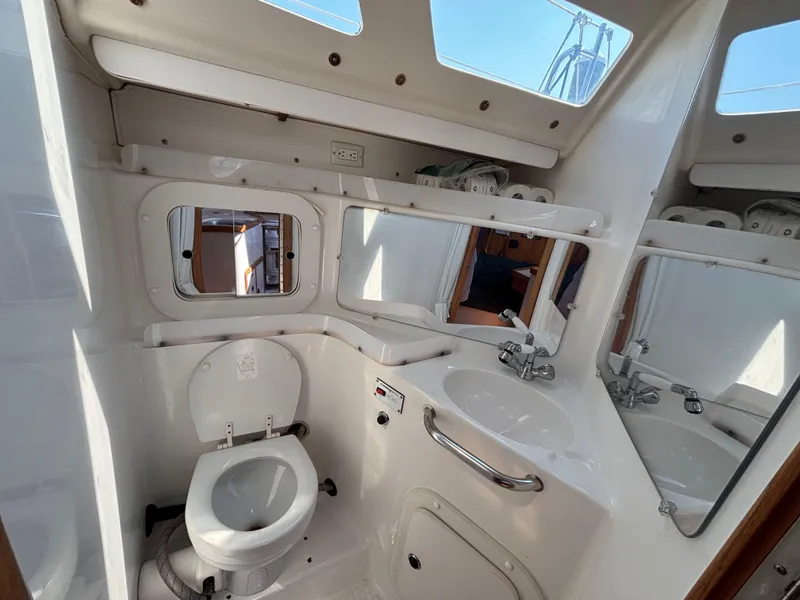 Slide: The Image of 1998 Catalina 320 yacht bathroom with toilet, sink, and mirrors. - 39