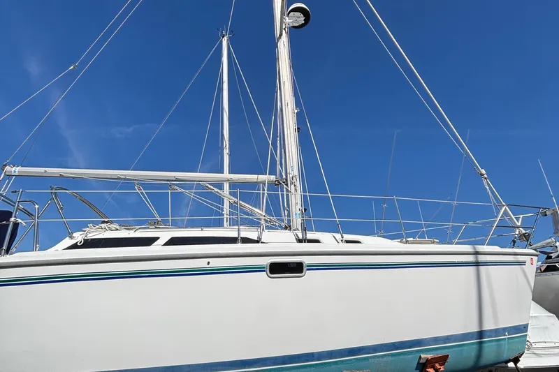 Slide: The Image of 1998 Catalina 320 sailboat with white hull and blue stripe under clear sky. - 4
