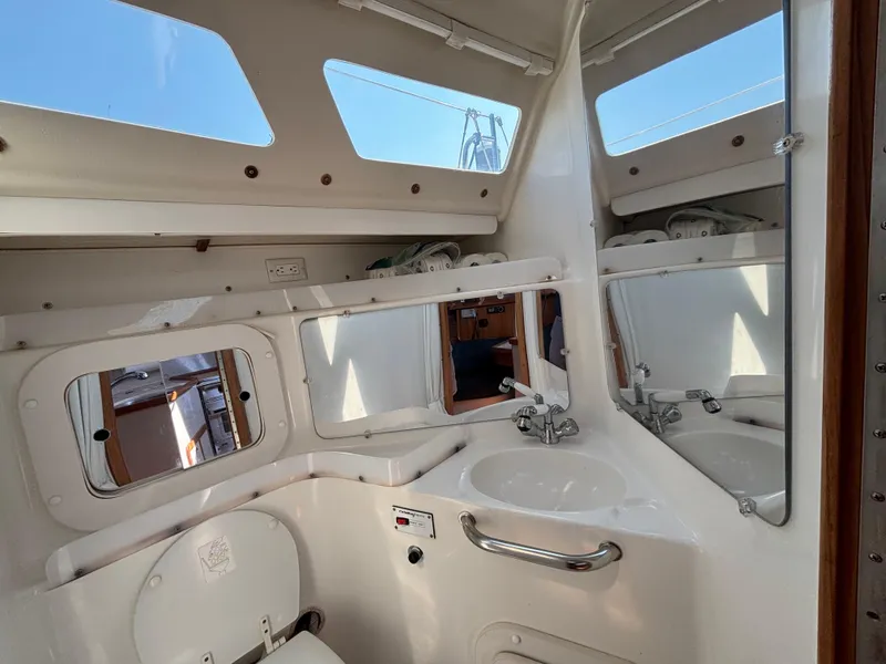 Slide: The Image of Interior of 1998 Catalina 320 sailboat bathroom with sink, mirror, and toilet. - 40