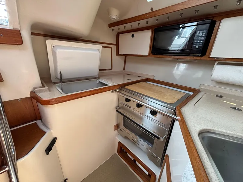 Slide: The Image of Compact kitchen in a 1998 Catalina 320 sailboat with stove, microwave, and storage. - 41