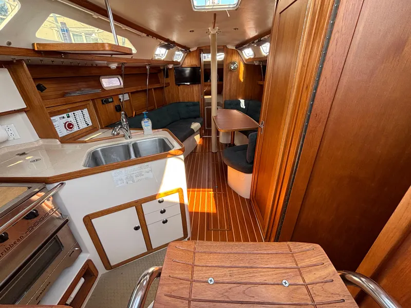 Slide: The Image of Interior of a 1998 Catalina 320 sailboat with wood finish and compact kitchen area. - 42